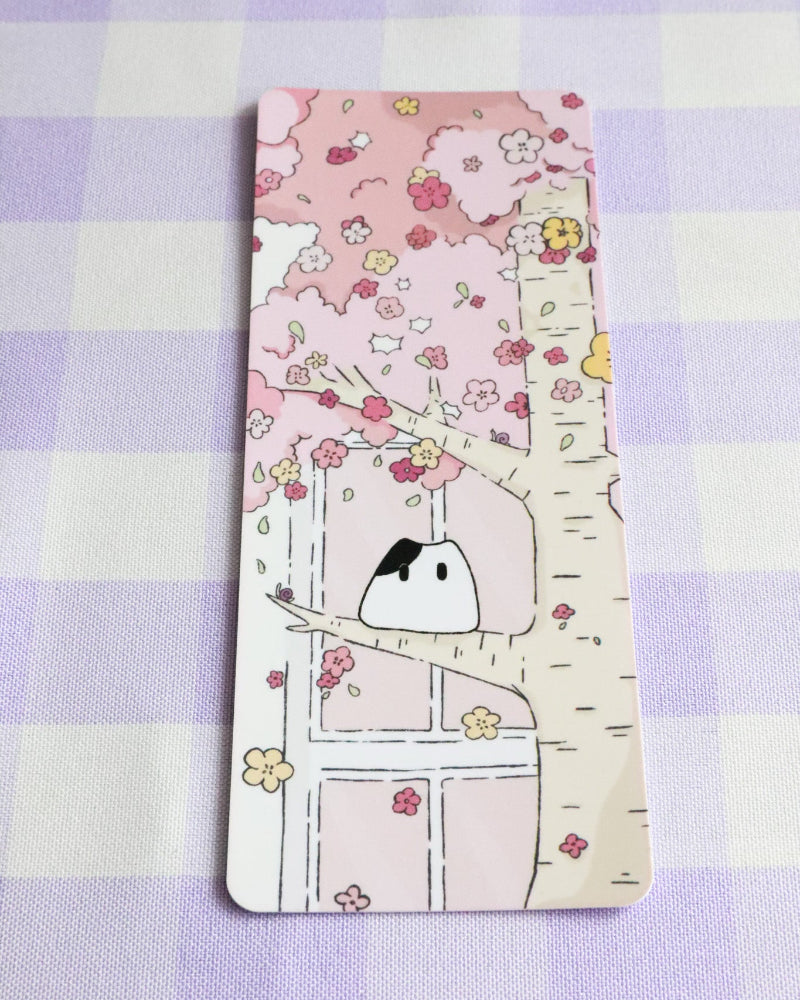 Decorative bookmark with a cartoon cat and floral design on a checkered background