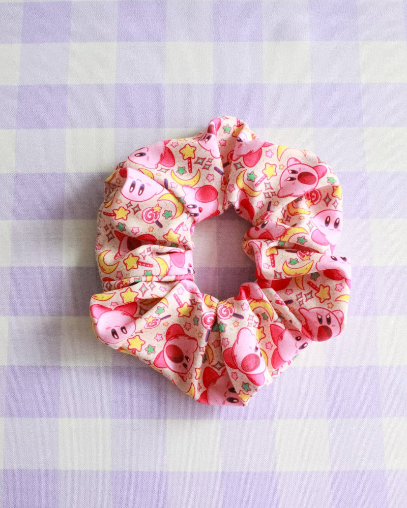 Pink scrunchie with cartoon characters on a purple and white checkered background