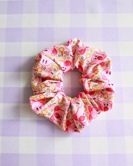 Pink scrunchie with cartoon characters on a purple and white checkered background