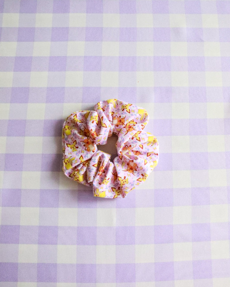 Scrunchie with floral pattern on a purple and white checkered background