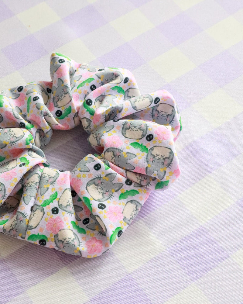 Two scrunchies with cat pattern on a pastel checkered background