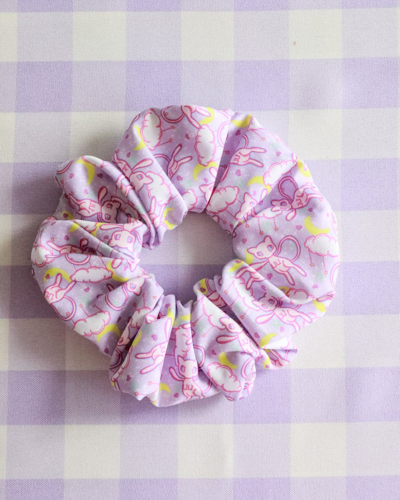 Pink scrunchie with a pattern on a purple and white checkered background
