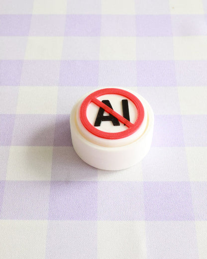Round object with a red circle and 'No AI' text on a checkered background