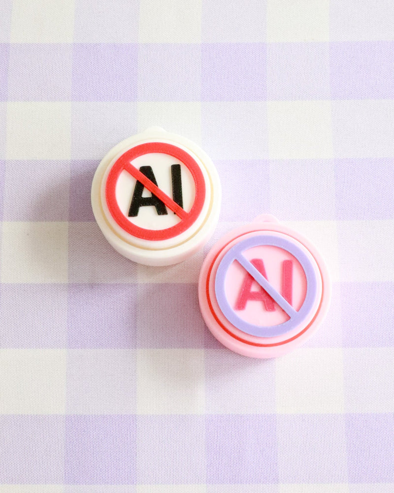 Two round stickers with 'No AI' symbols on a checkered background