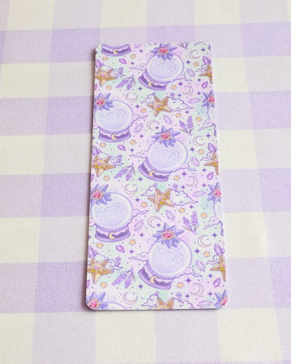 Fabric with a pattern of purple teapots and flowers on a checkered background