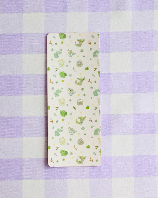 Small rectangular fabric sample with green patterns on a purple and white checkered background
