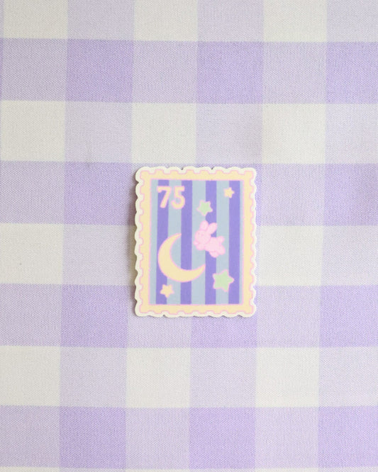 Decorative sticker with a moon and stars design on a purple and white checkered background