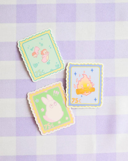 Three colorful cards with cartoon characters on a purple and white checkered background