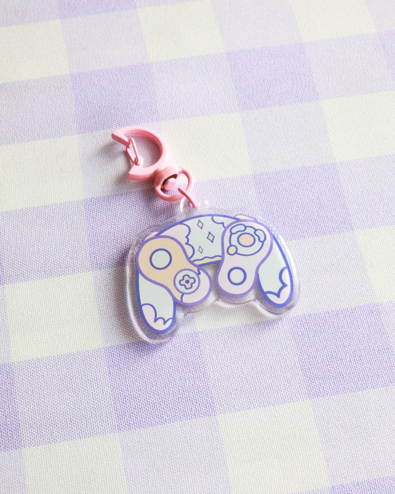 Pastel-colored gaming controller charm on a checkered background