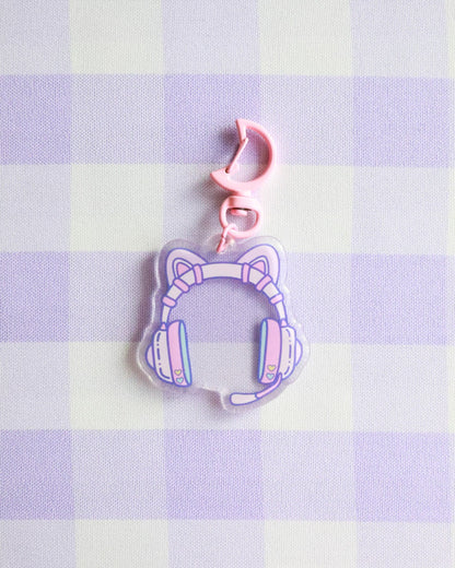 Pastel-colored cat-shaped hair clip with headphones on a checkered background