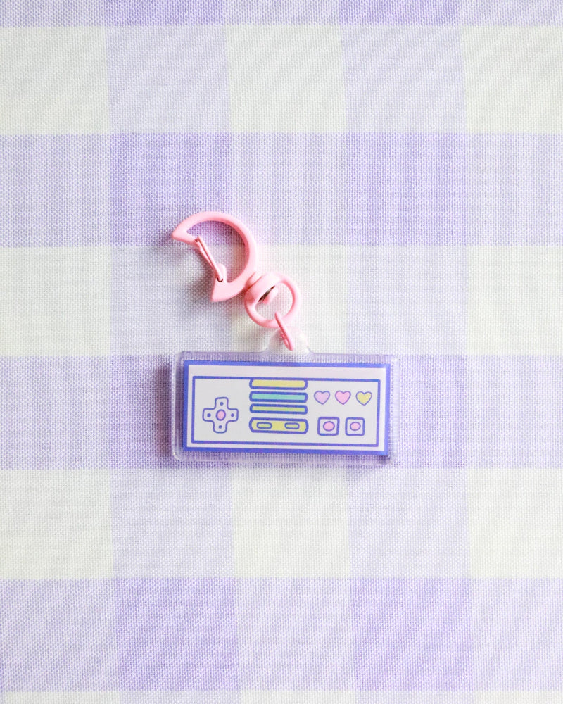 Keychain with a retro gaming console design on a purple and white checkered background