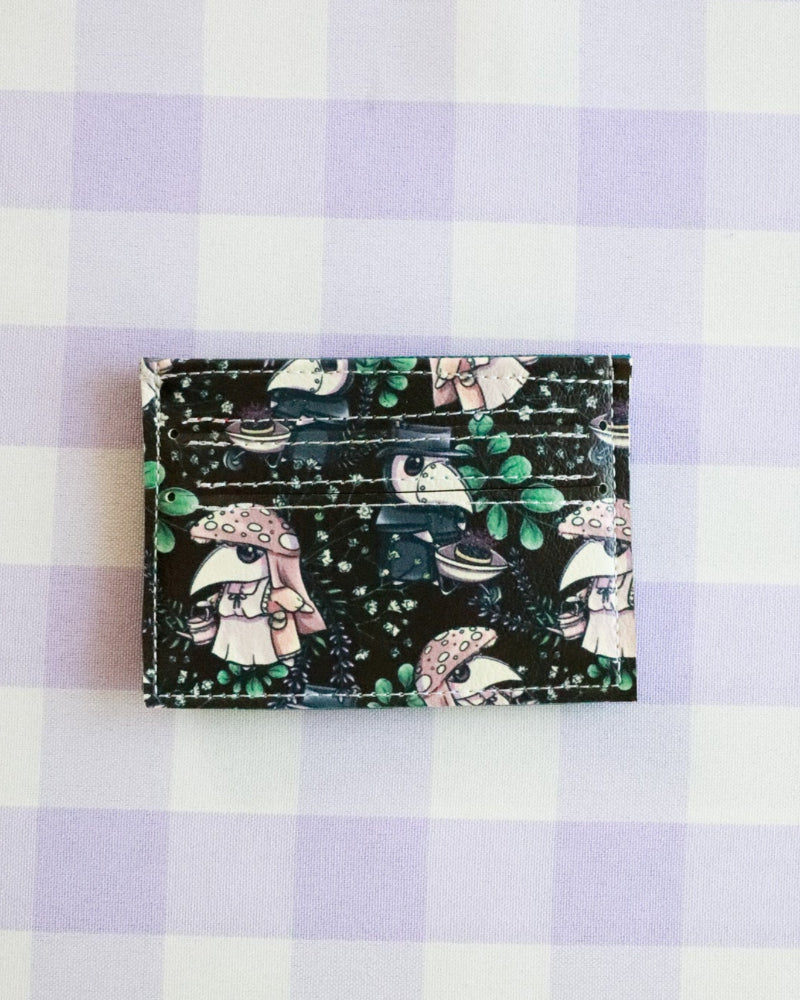 Cardholder with cartoon designs on a purple and white checkered background