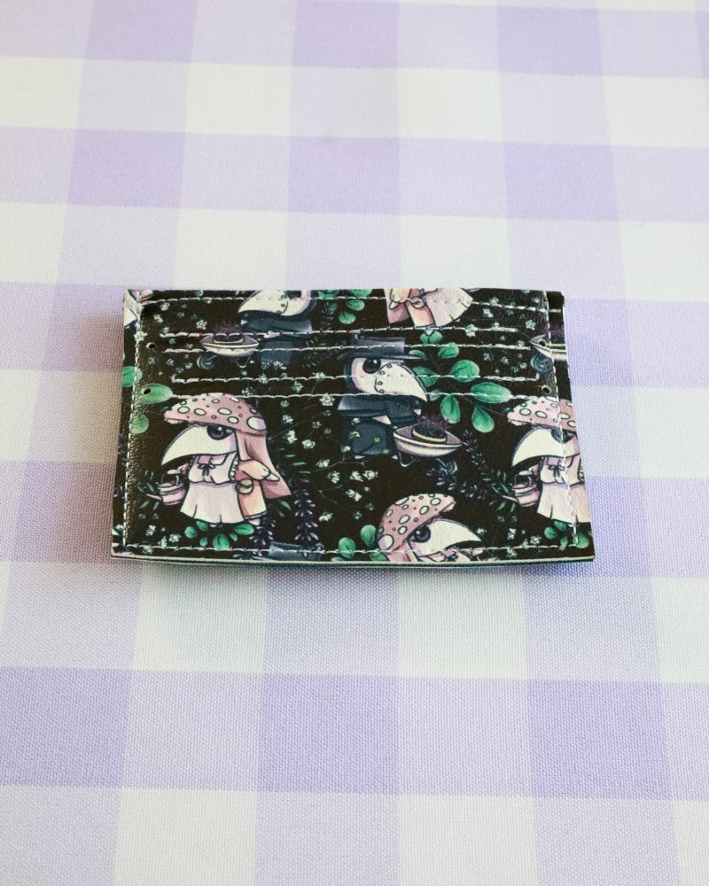 Cardholder with cartoon character design on a purple and white checkered background