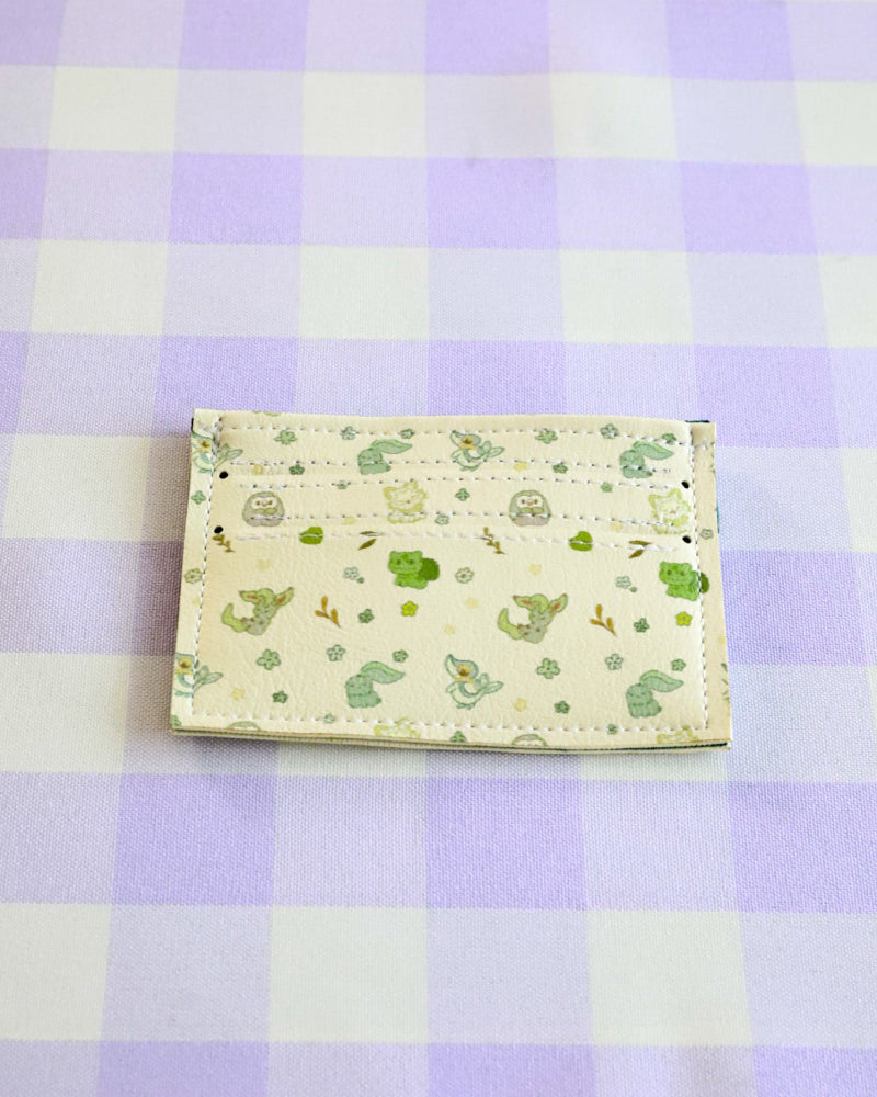 Small pouch with green pattern on a purple and white checkered background