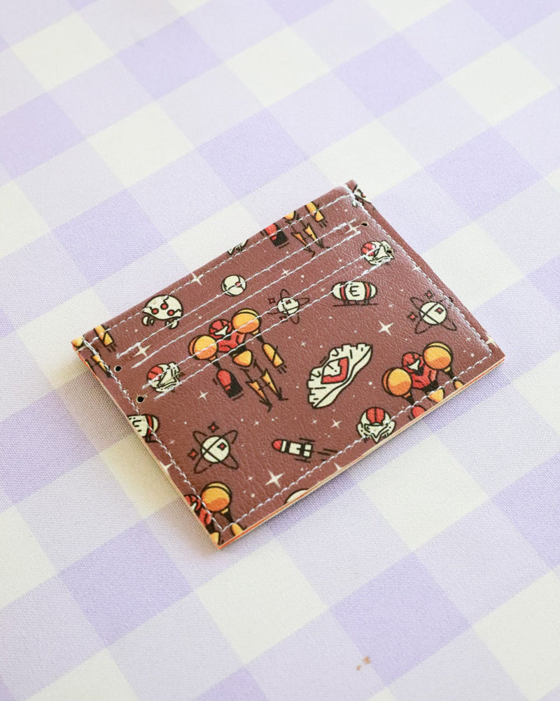 Cardholder with space-themed design on a checkered background