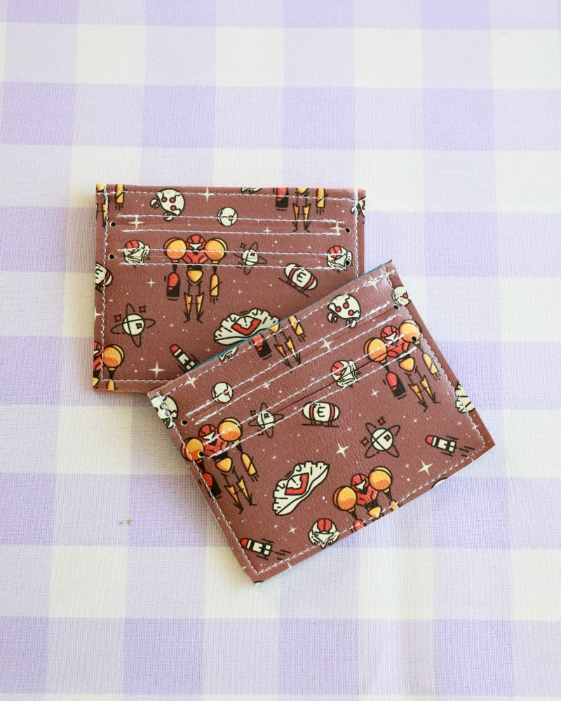 Two fabric coasters with space-themed design on a purple and white checkered background