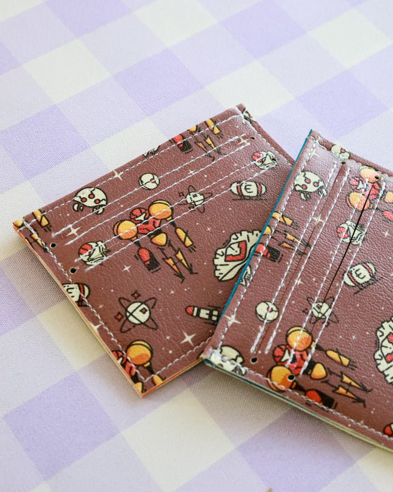Two card holders with space-themed design on a checkered background