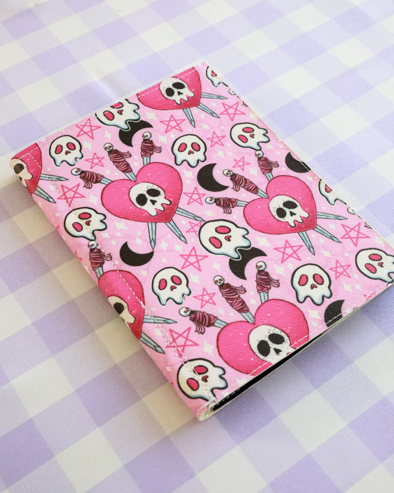 Pink notebook with skull design on a checkered background