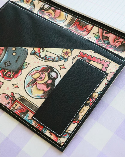 Black leather wallet with tattoo-themed design on a white background