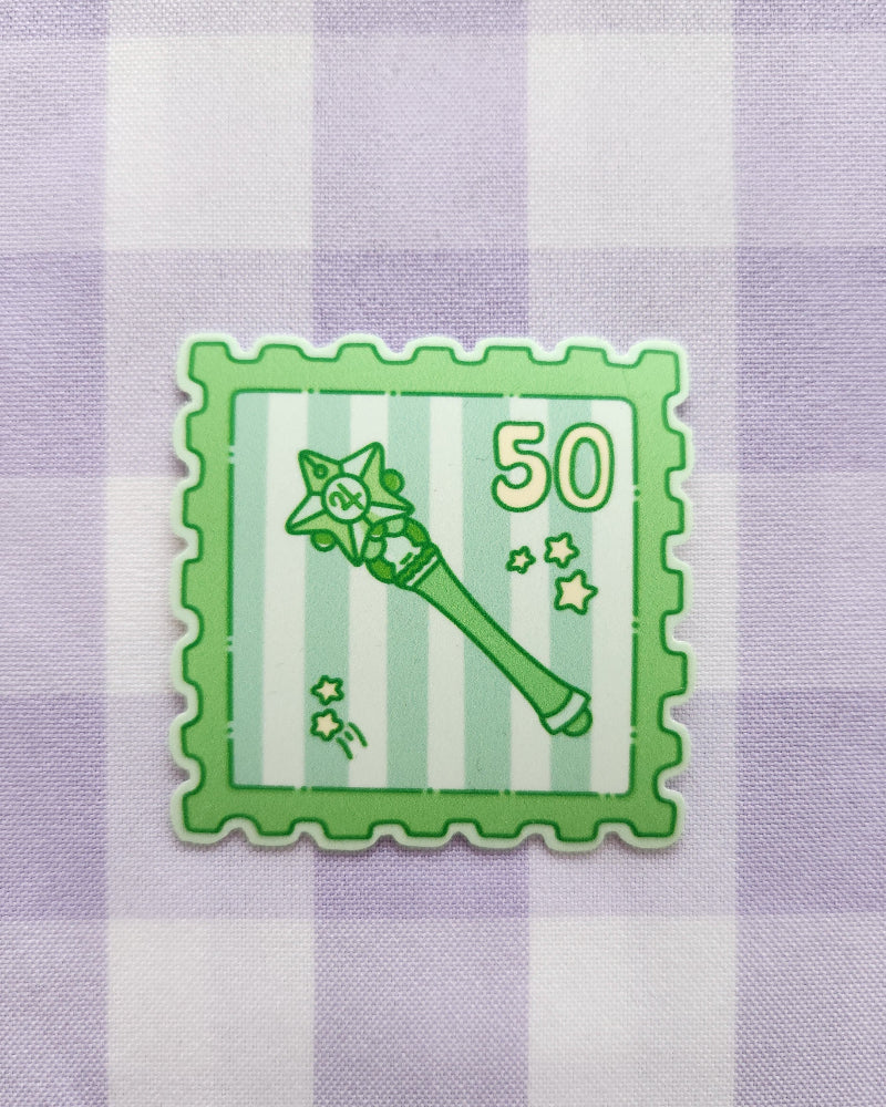 Green postage stamp design with a wand on a purple and white checkered background