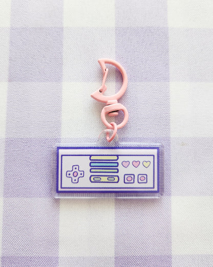 Pink cat-shaped clip on a purple and white checkered background