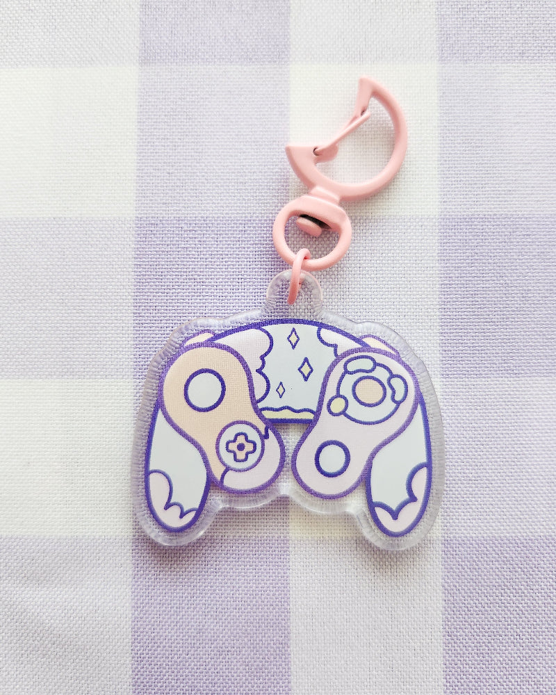 Clear charm with purple and pink design on a checkered fabric background
