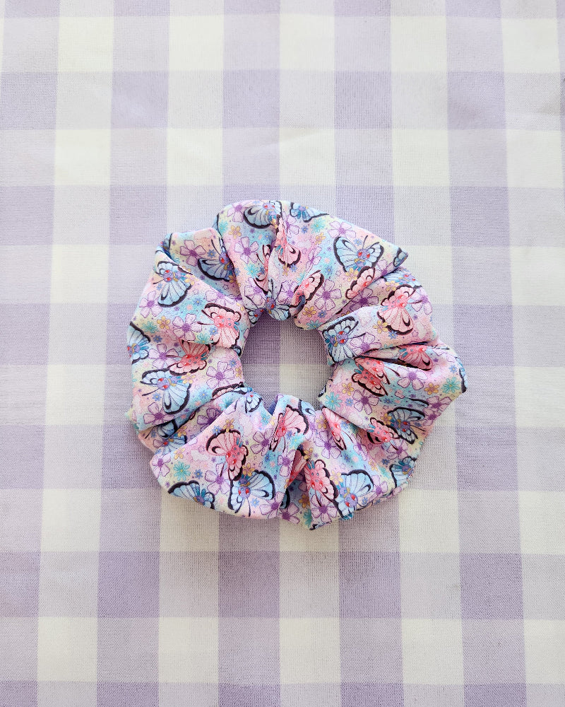 Floral patterned scrunchie on a purple and white checkered background