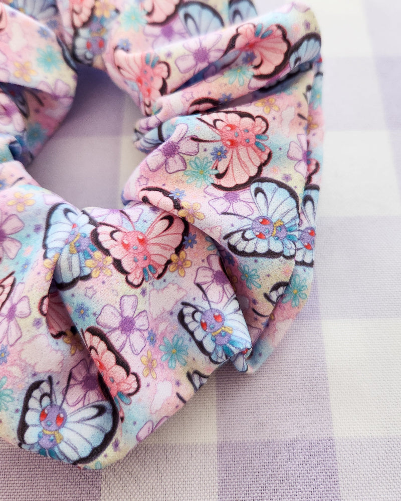 Floral and butterfly-patterned travel pillow on a white background