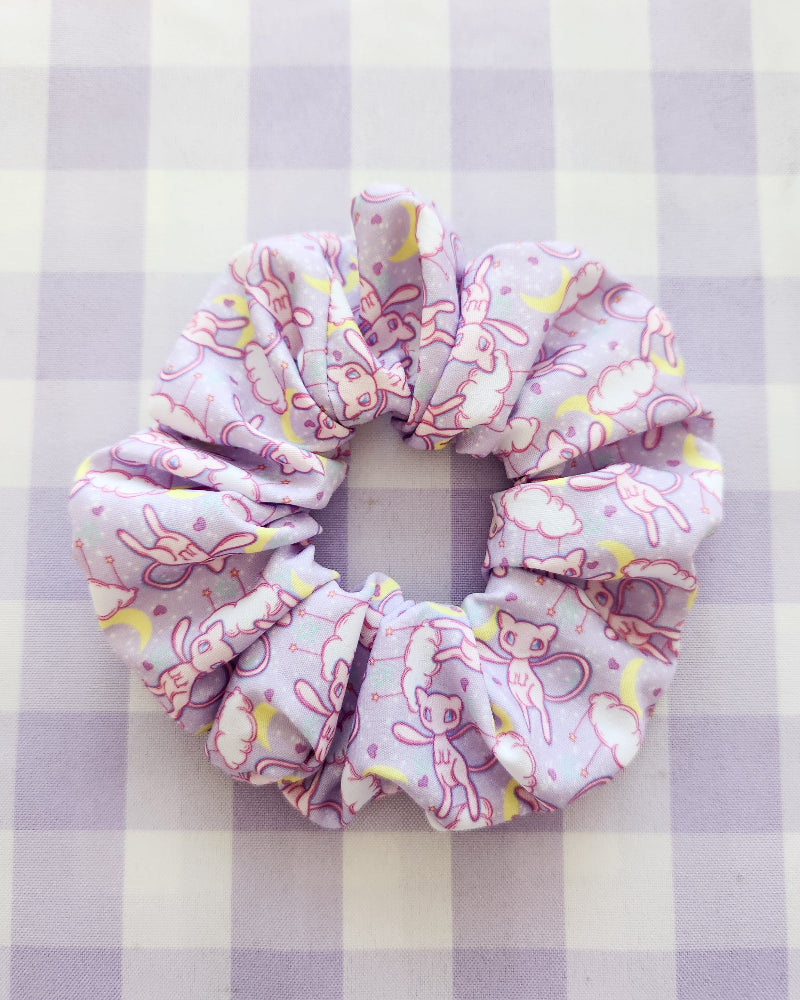 Pink scrunchie with floral pattern on a purple and white checkered background