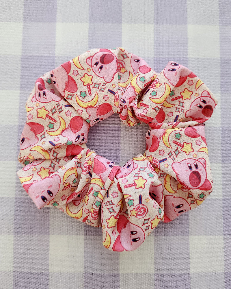 Pink scrunchie with cartoon character pattern on a checkered background