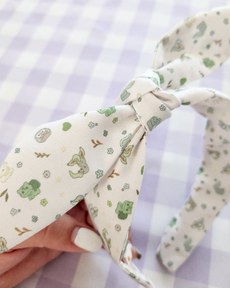 Floral patterned headband with bow held against a checkered background