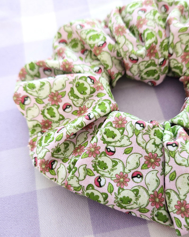 Green and pink patterned scrunchie on a light purple background
